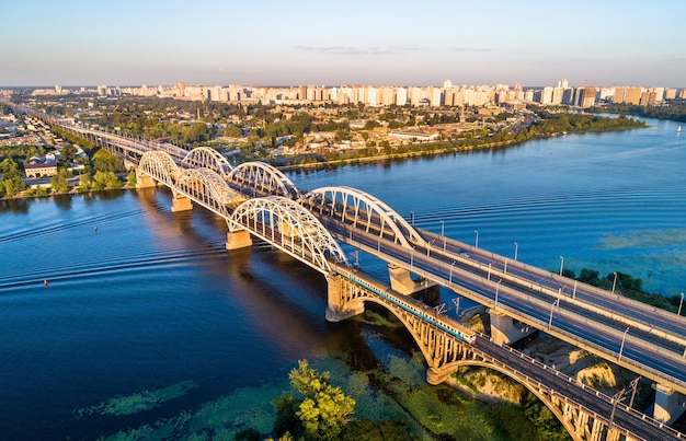 Vista aérea de un tren eléctrico urbano de Kiev cruzando el Dnieper por el puente Darnytsia. Ucrania, Europa del Este