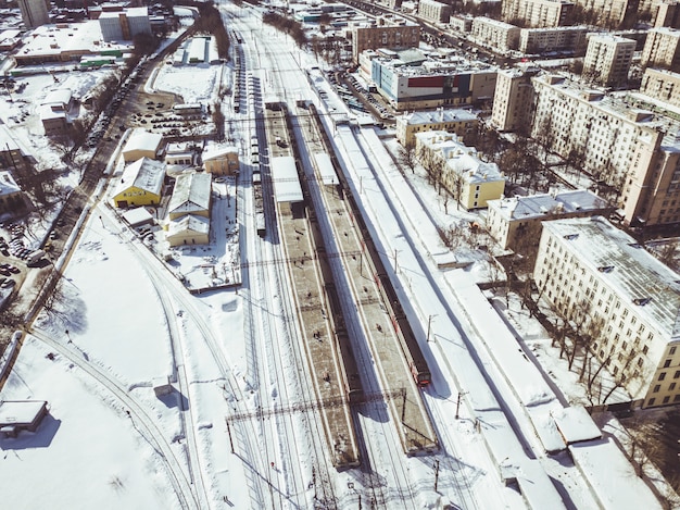 Vista aérea del tren en ferrocarril pasando por la ciudad en un día de invierno