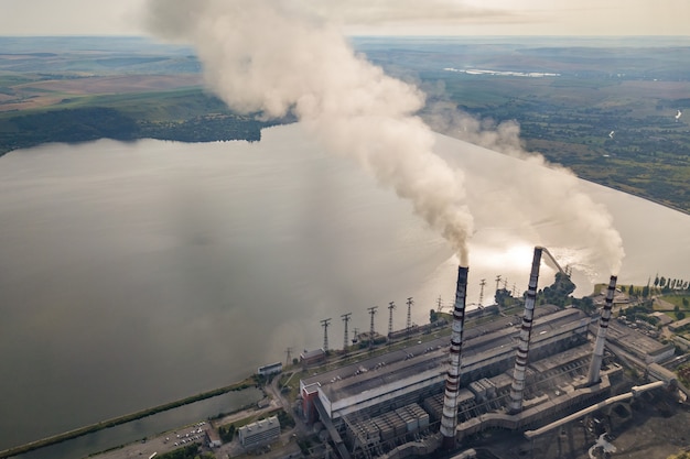 Vista aérea de tuberías de alta chimenea con humo gris de la central eléctrica de carbón. Producción de electricidad con combustibles fósiles.