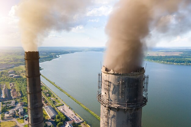 Vista aérea de los tubos altos de la planta de energía de carbón con atmósfera contaminante de la chimenea negra. Producción de electricidad con concepto de combustibles fósiles.