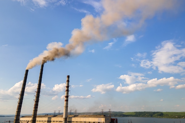 Vista aérea de los tubos altos de la planta de energía de carbón con atmósfera contaminante de la chimenea negra. Producción de electricidad con concepto de combustibles fósiles.