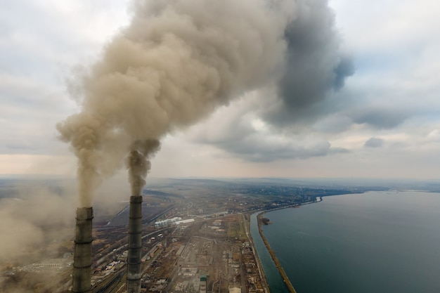 Vista aérea de los tubos altos de la planta de energía de carbón con humo negro subiendo la atmósfera contaminante.