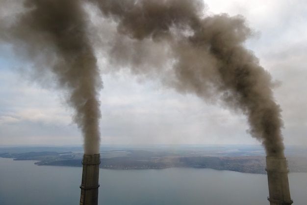 Vista aérea de los tubos altos de la planta de energía de carbón con humo negro subiendo la atmósfera contaminante.