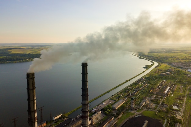 Vista aérea de los tubos altos de la planta de energía de carbón con humo negro subiendo la atmósfera contaminante.