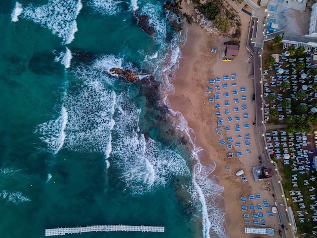 Vista aérea de tumbonas entre la ciudad turística y el mar azul