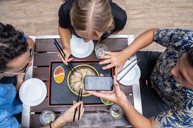 Vista aérea de varias personas recogiendo comida asiática de un plato