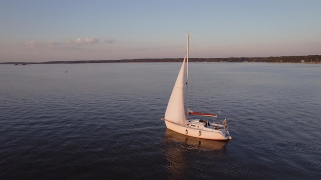 Vista aérea de un velero en un lago al atardecer