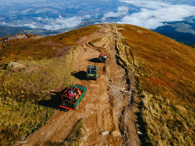 Vista aérea de los viajes todoterreno suv subiendo por la colina de la montaña