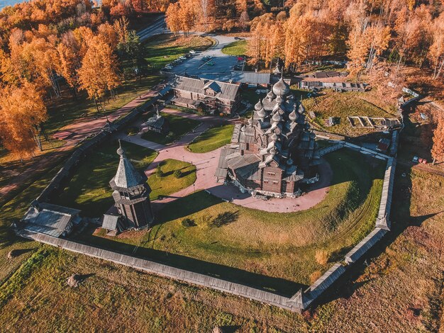 Vista aérea de la vieja iglesia de madera Manor teólogo en el bosque de otoño. Rusia, San Petersburgo.