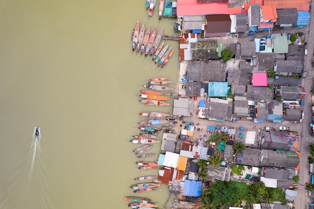 Vista aérea vista superior da vila de pescadores com barcos de pesca e telhado de casa no cais em suratthani Tailândia vista de alto ângulo