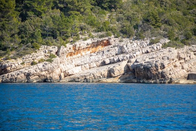 Vista desde el agua de la costa rocosa de la isla en Croacia