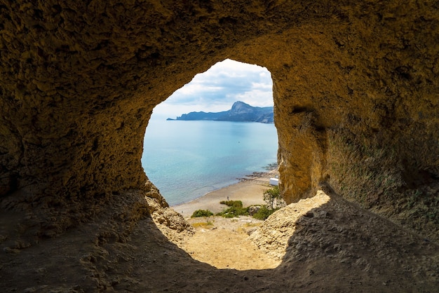 Vista al mar desde una pequeña cueva en la ladera del arpa eólica de las montañas costeras. Cabo Alchak, Sudak, Crimea.