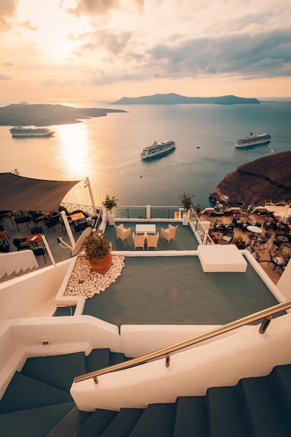 Una vista al mar desde una terraza en la azotea con vista al mar y la puesta de sol detrás de él.