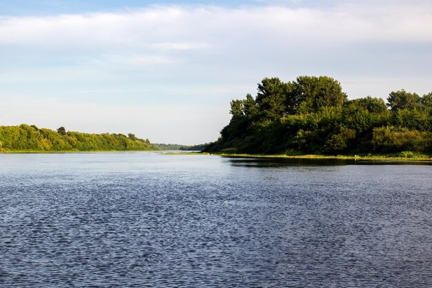 Vista al río y al bosque de verano bajo un cielo azul