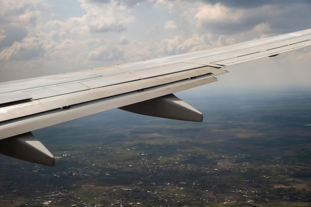 Vista del ala del avión jet aterrizando en el aeropuerto con mal tiempo. Concepto de transporte aéreo y de viajes.