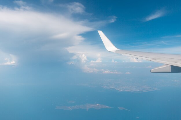 Vista de ala de avión por la ventana el fondo de cielo nublado, viajes y vacaciones concepto de vacaciones