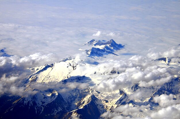 Vista de los Alpes suizos nevados desde las alturas sobre las nubes blancas.