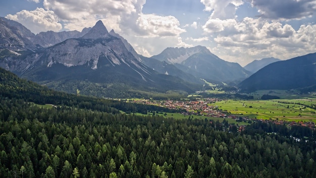 Vista de altas montañas rocosas y bosques densos y verdes en un día soleado