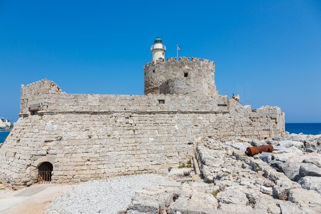 Vista alternativa de la fortaleza de San Nicolás con el faro en el puerto del puerto de Mandaki isla de Rodas Grecia