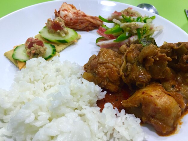 Vista de alto ángulo de arroz y curry de carne con ensalada servida en un plato