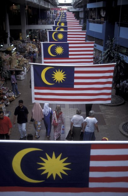 Foto vista de alto ángulo de la bandera de malasia colgando sobre la gente caminando por la calle