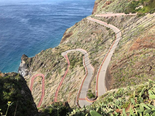 Foto vista de alto ángulo de la carretera por el mar contra la montaña