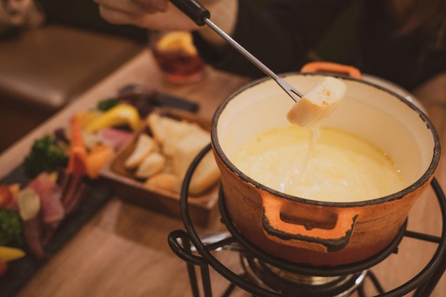 Vista de alto ángulo de comer fondue de queso para la cena