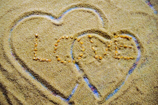 Foto vista de alto ángulo de forma de corazón en la arena en la playa