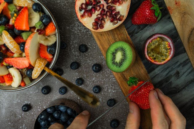 Foto vista de alto ángulo de frutas cortadas a mano en la tabla de corte con cuchillo