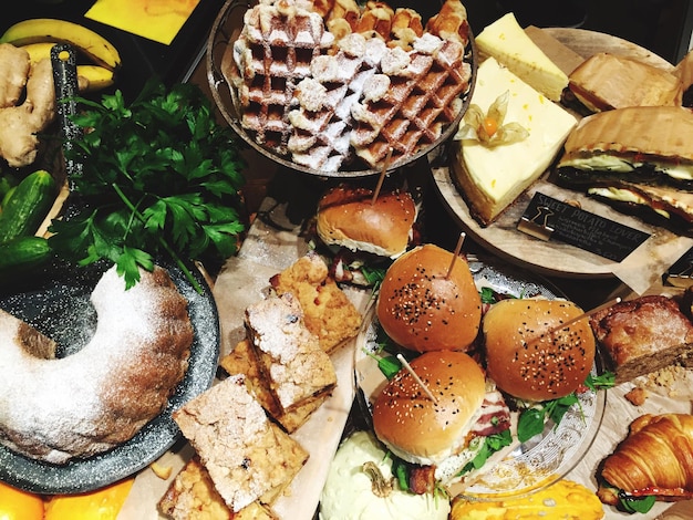 Vista de alto ángulo de hamburguesas y postres en la mesa