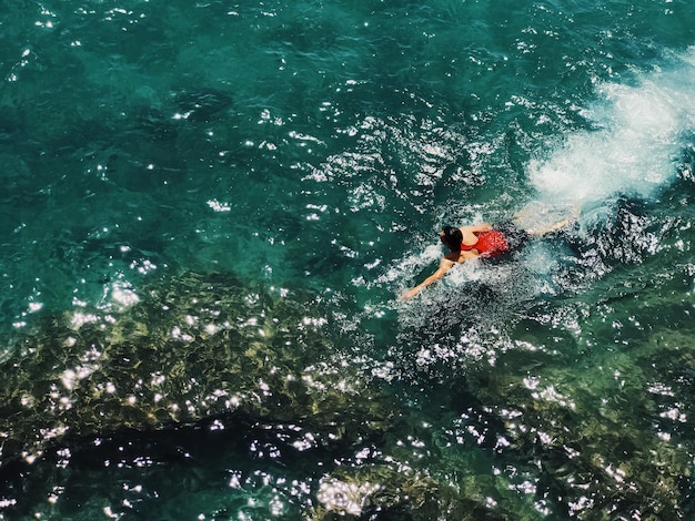 Foto vista de alto ángulo de un hombre nadando en el mar
