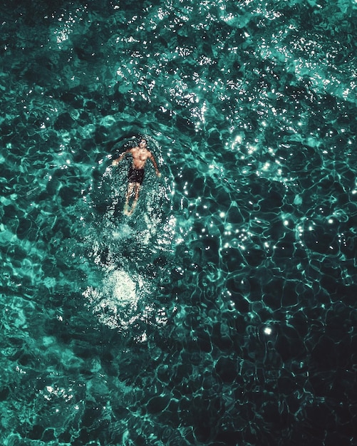 Foto vista de alto ángulo de un hombre nadando en el mar