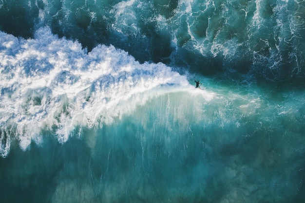 Vista de alto ángulo de un hombre surfeando en el mar