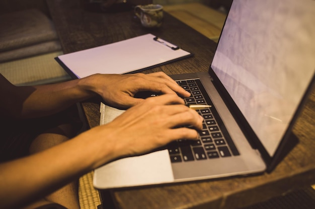 Vista de alto ángulo de un hombre usando una computadora portátil en la mesa