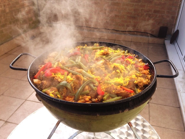 Vista de alto ángulo del humo que sale de la paella en la sartén