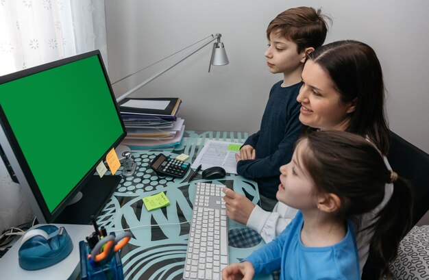 Vista de alto ángulo de la madre con los niños usando la computadora en casa