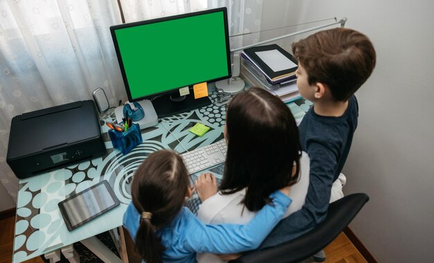 Vista de alto ángulo de la madre con los niños usando la computadora en casa