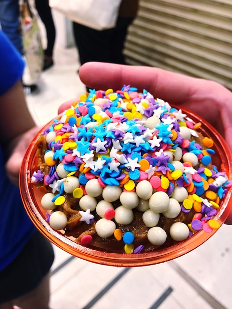 Foto vista de alto ángulo de la mano sosteniendo caramelos multicolores