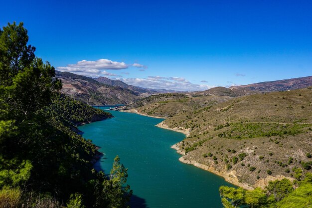 Vista de alto ángulo del mar y las montañas contra el cielo azul