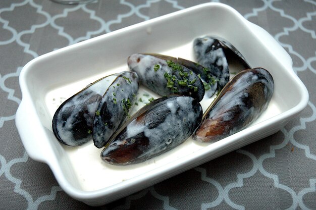 Vista en alto ángulo de los mejillones en un plato sobre la mesa