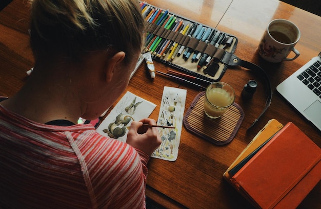 Vista de alto ángulo de una mujer pintando un conejo de Pascua