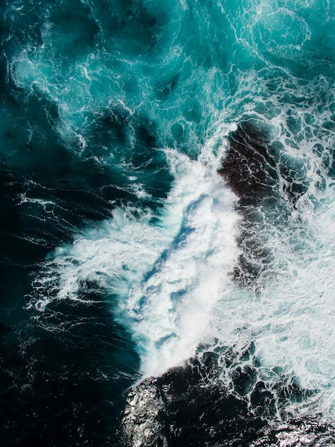 Vista de alto ángulo de las olas chapoteando sobre las rocas