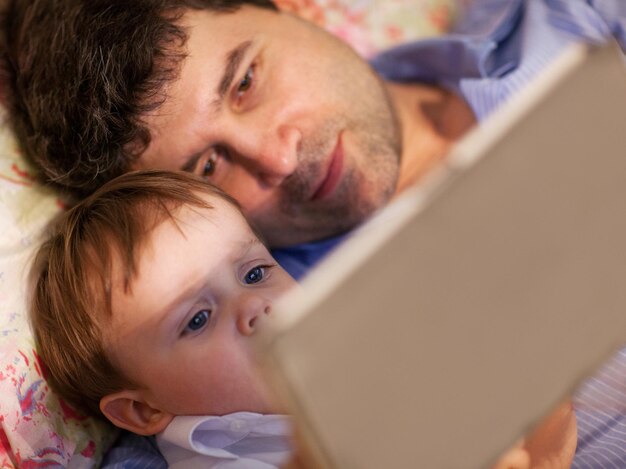 Foto vista de alto ángulo de padre e hijo mirando en una tableta digital