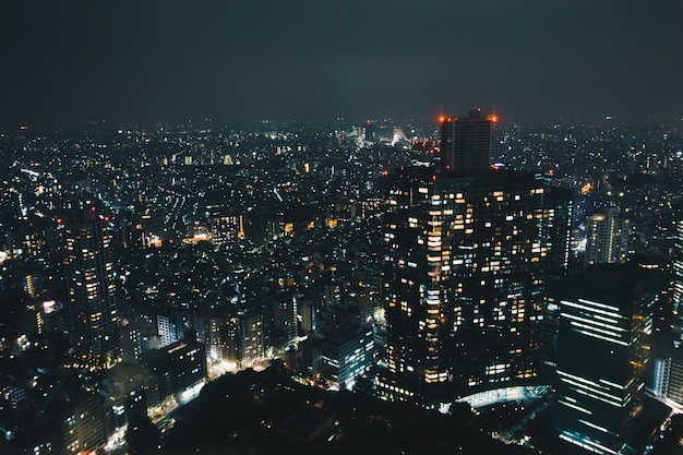 Vista de alto ángulo del paisaje urbano iluminado contra el cielo nocturno