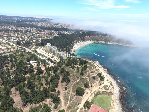 Vista de alto ángulo del paisaje urbano y el mar contra el cielo