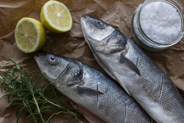 Vista de alto ángulo de peces con ingredientes en papel marrón