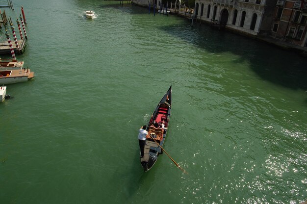 Foto vista de alto ángulo de personas en un barco en el canal