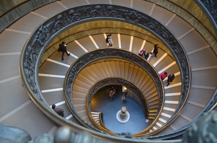 Foto vista de alto ángulo de personas caminando por la escalera de espiral en los museos del vaticano