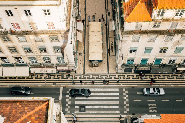 Foto vista de alto ángulo de personas por coches en la calle en medio de edificios