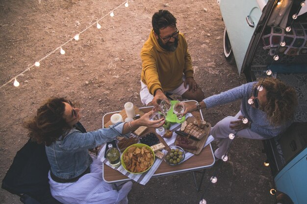 Foto vista de alto ángulo de personas comiendo mientras acampan